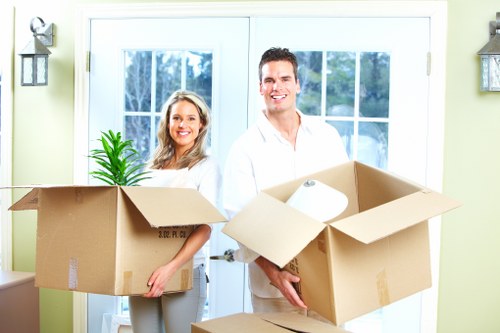 Professional movers carrying furniture through a Wimbledon home